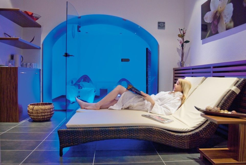 Žena relaxuje na ležadle vo wellness centre s modrým osvetlením.