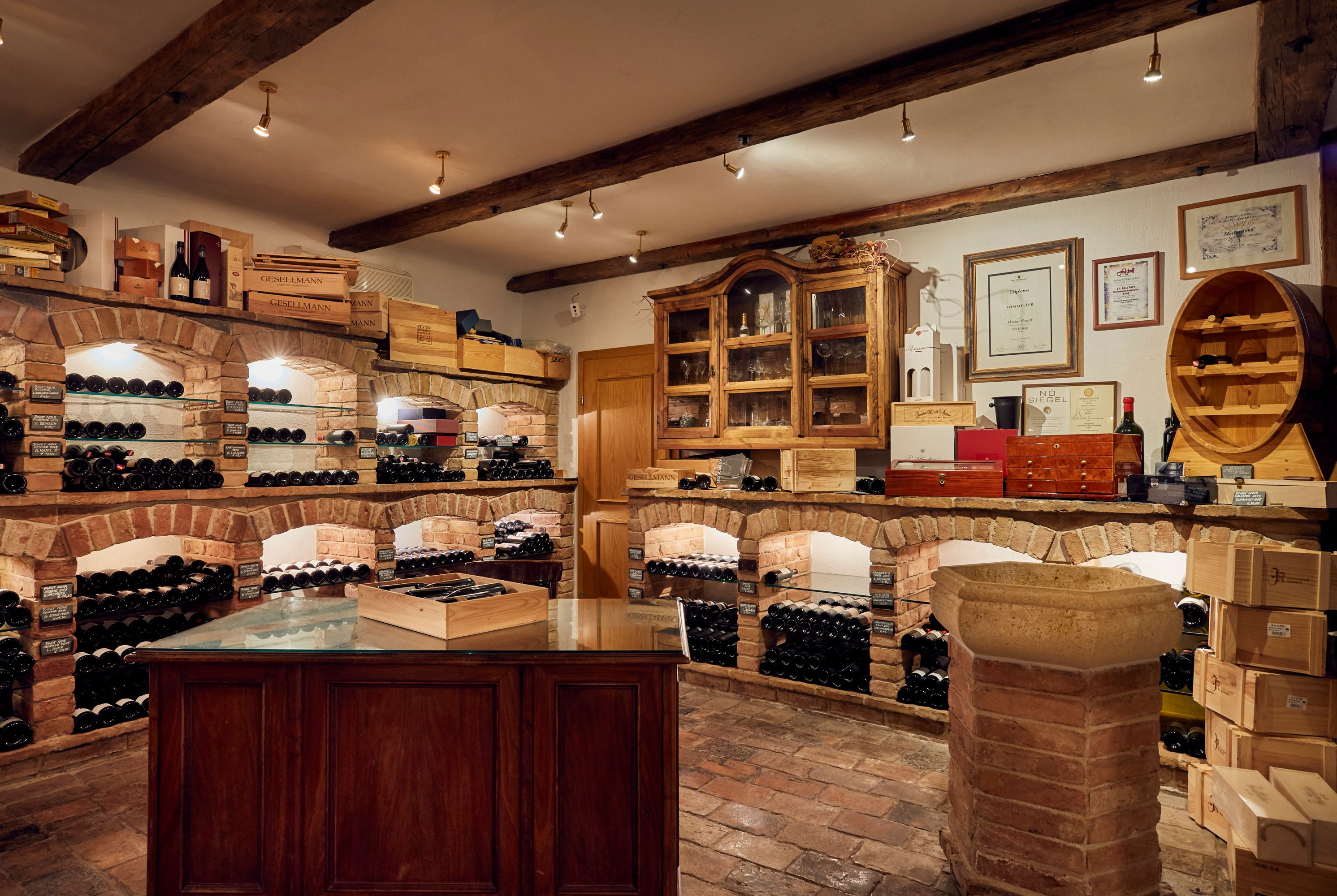 Vínna pivnica s murovanými policami a fľašami vína.