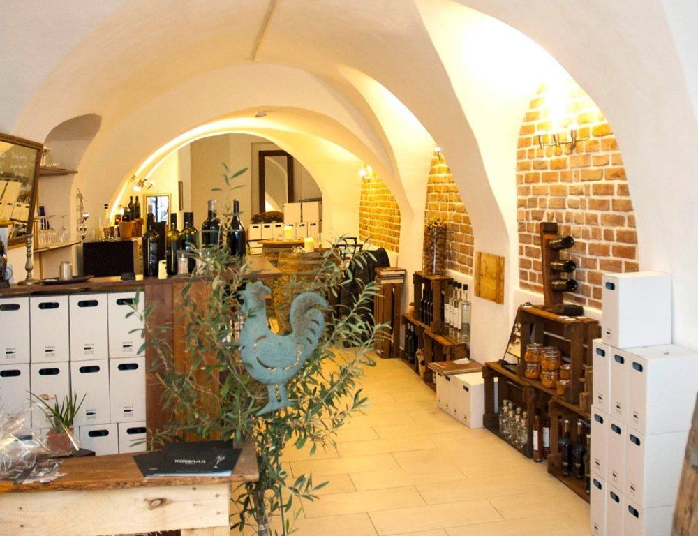 Pohľad do interiéru vinárne s tehlovými stenami a fľašami vína.