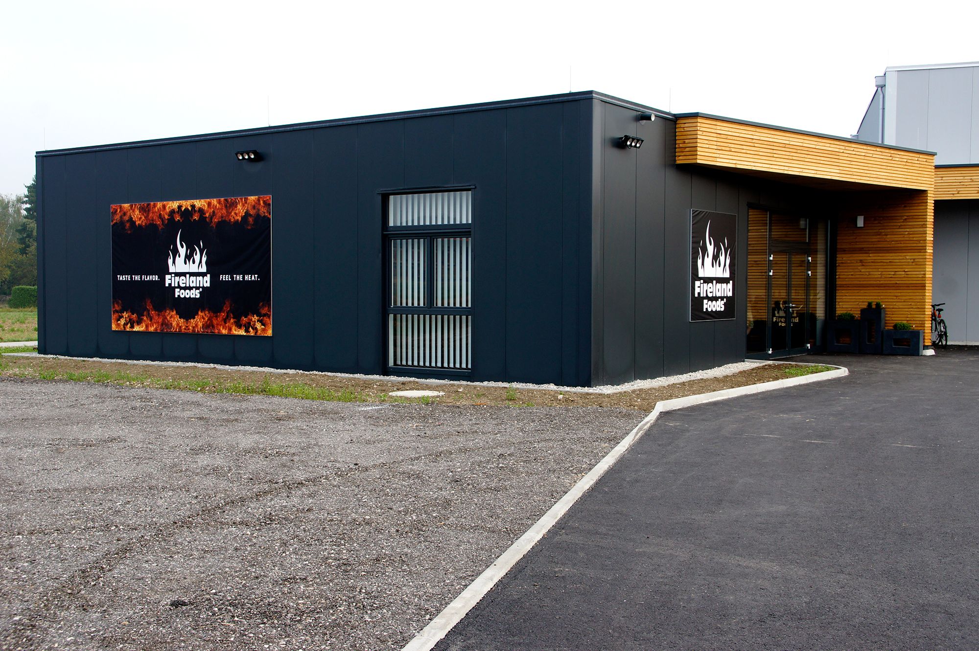 Exteriérový pohľad na modernú budovu s logom a sloganom Fireland Foods.