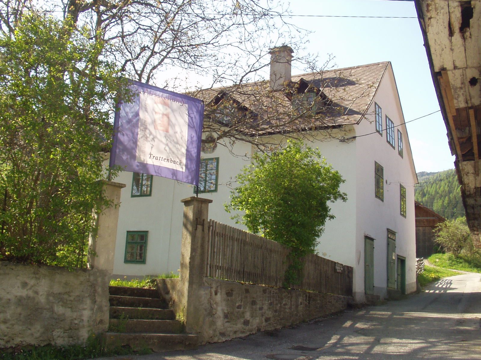 Biela budova so zelenými okennými rámami a nápisom "Trattenbach".