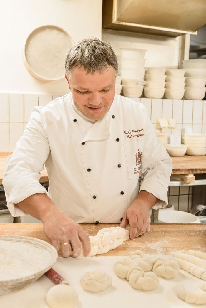 Majster pekár formuje cesto v pekárni.