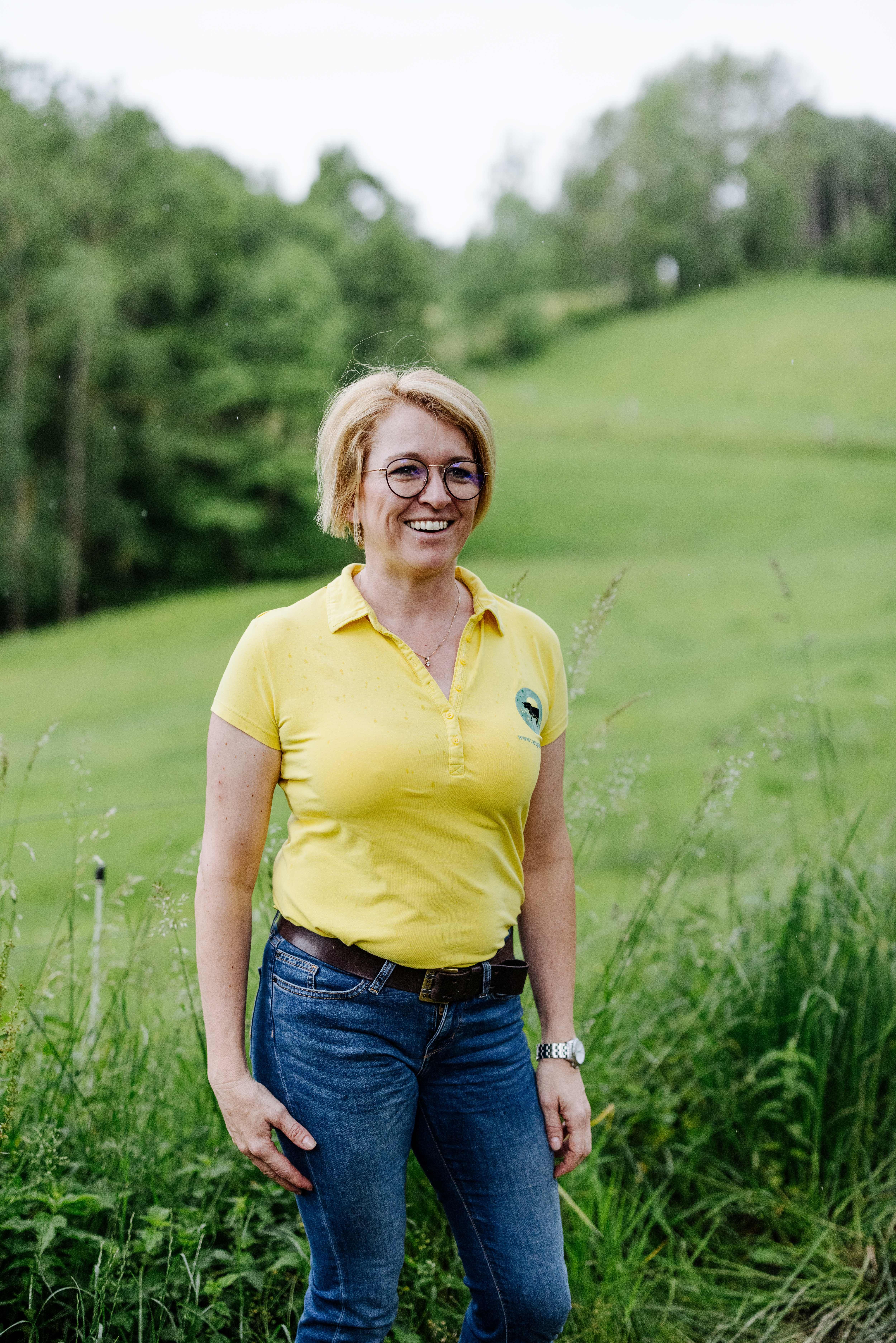 Majiteľka Sandra Anderlová stojí s úsmevom na zelenej lúke.