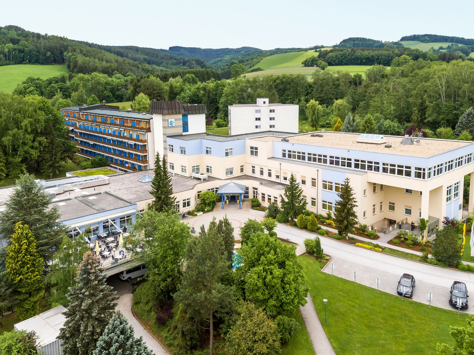 Letecký pohľad na veľký komplex budov v zelenej krajine.