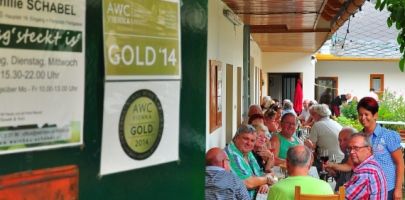 Ľudia sedia pri dlhom stole v krytej vonkajšej časti reštaurácie.