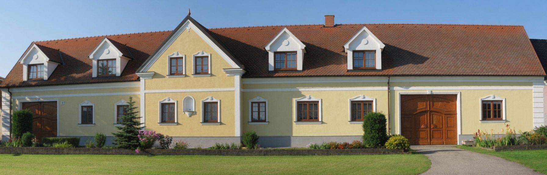 Žltý dom s červenou škridlovou strechou a niekoľkými oknami, obklopený udržiavanou záhradou.