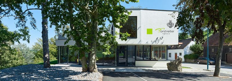 Moderný vinársky pavilón v Hollenburgu obklopený stromami.