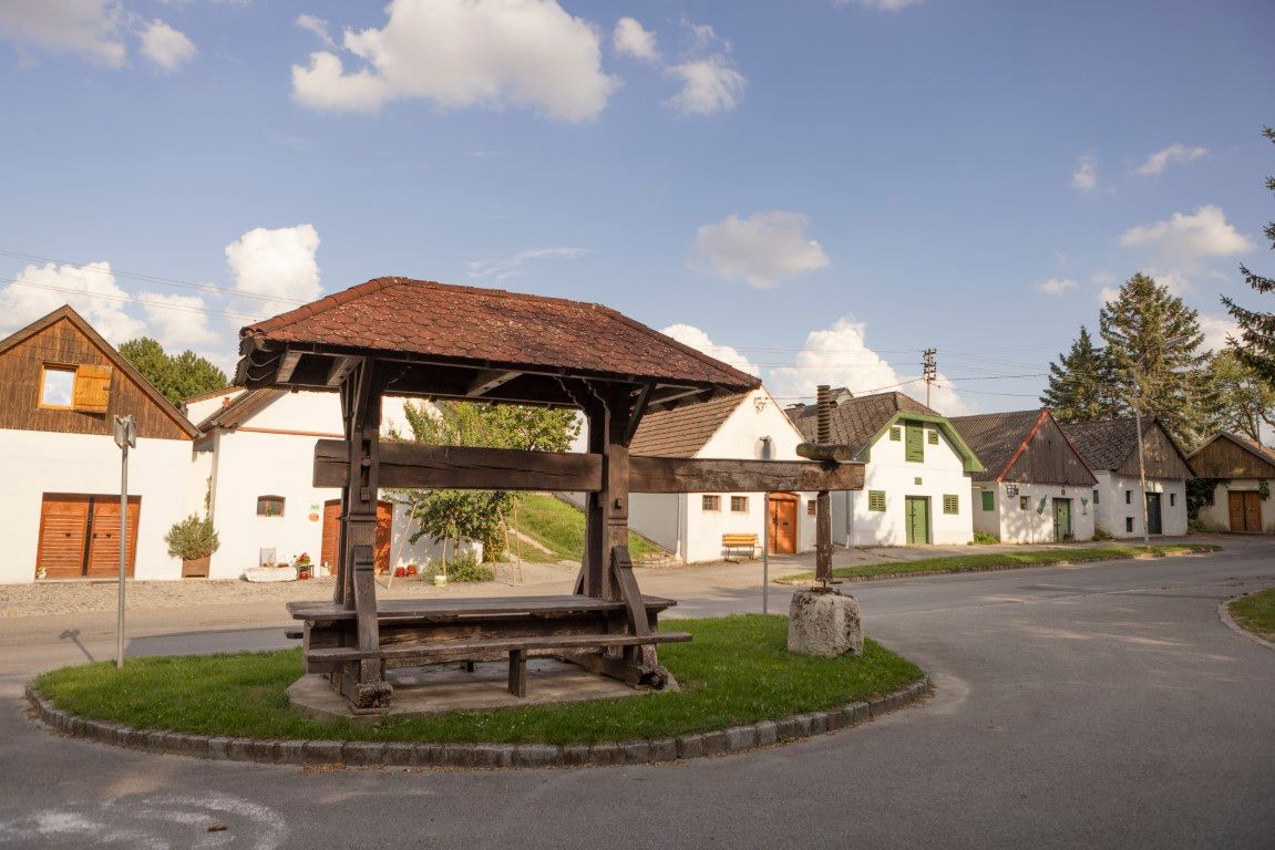 Historický lis na víno v Kettlasbrunne pred tradičnými domami v pivničných uličkách.