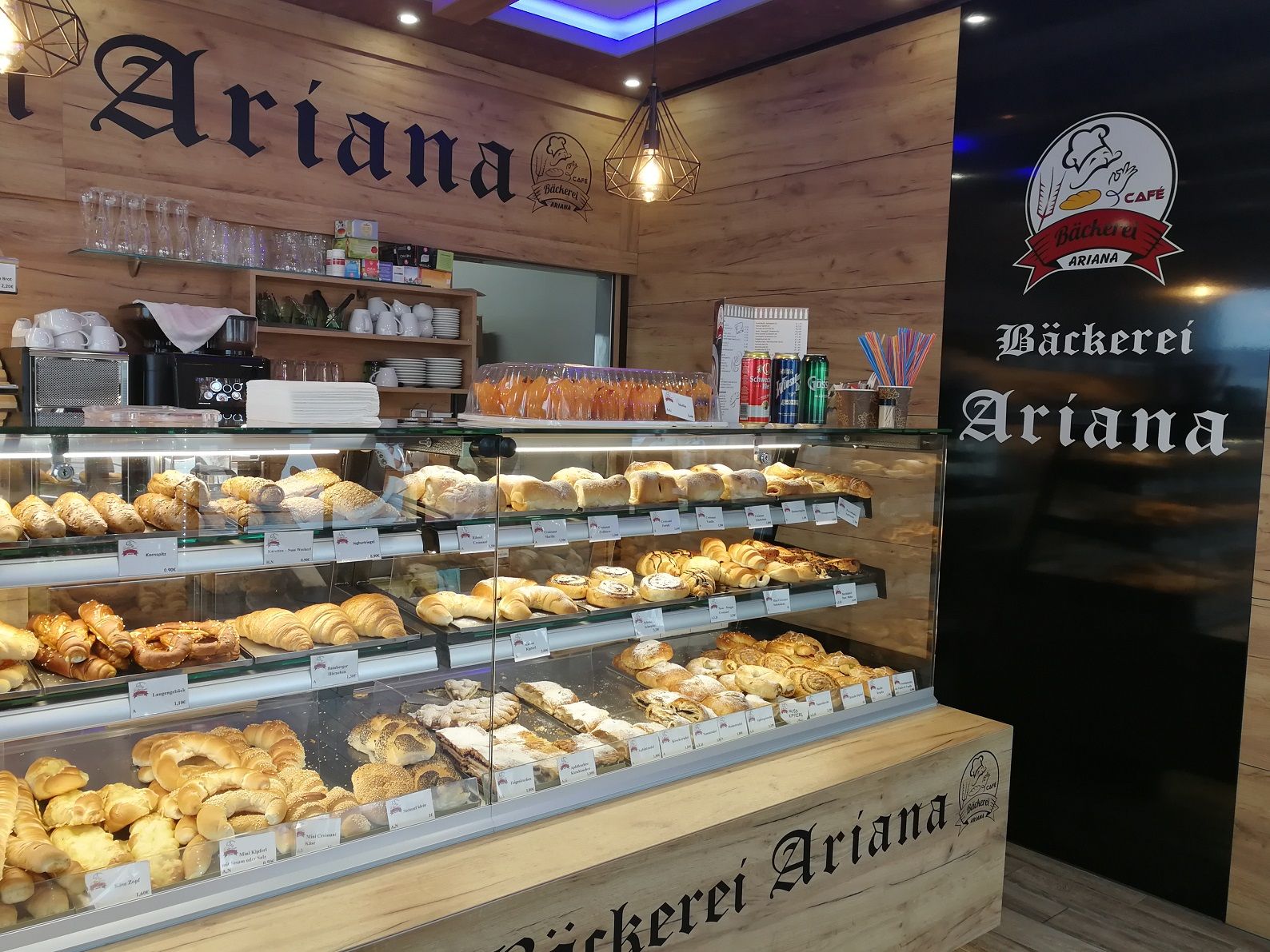 Pohľad do interiéru pekárne Ariana s vitrínou plnou pečiva.