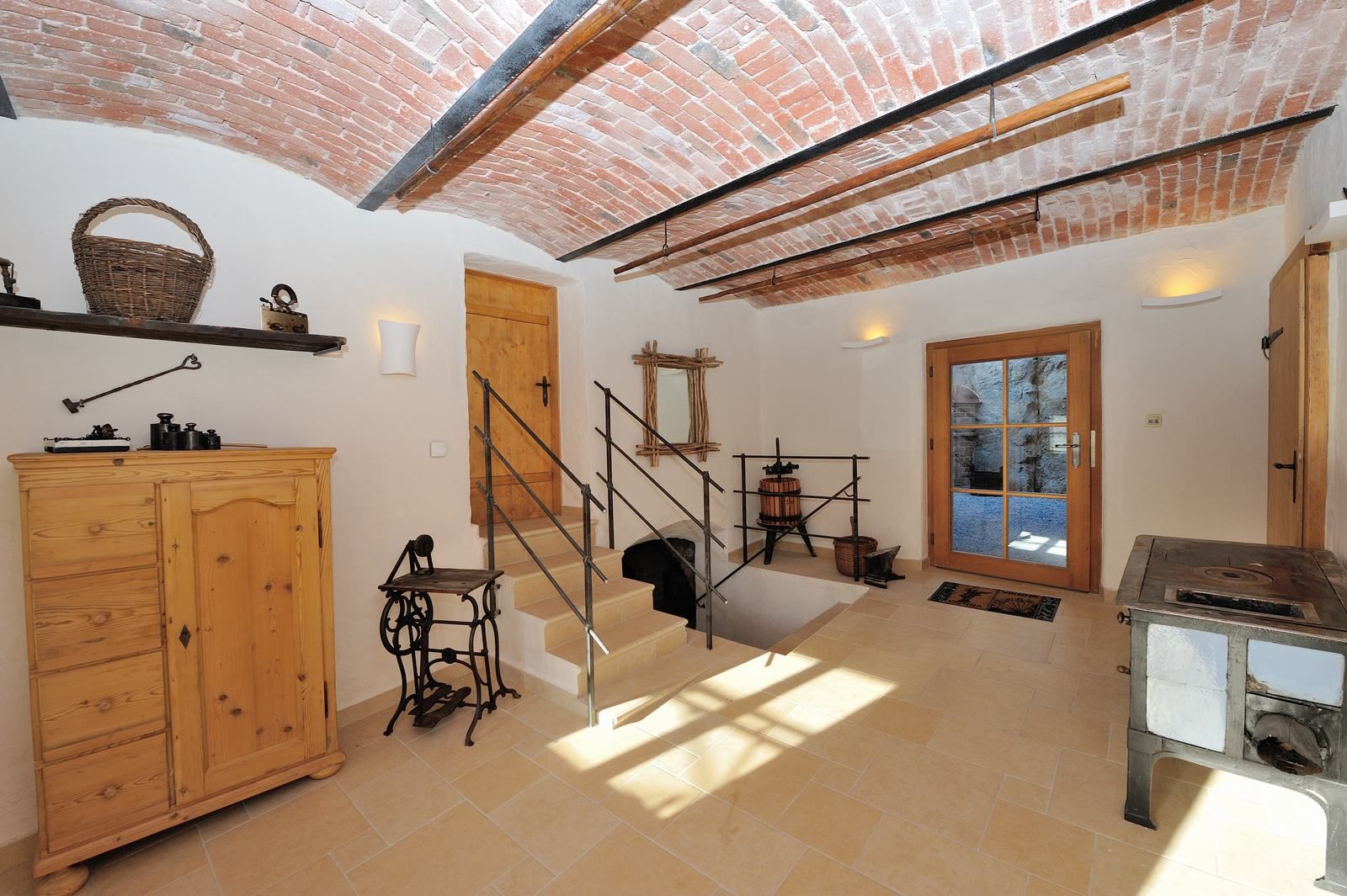 Interiér s klenutým stropom, dreveným nábytkom a starožitnými predmetmi.