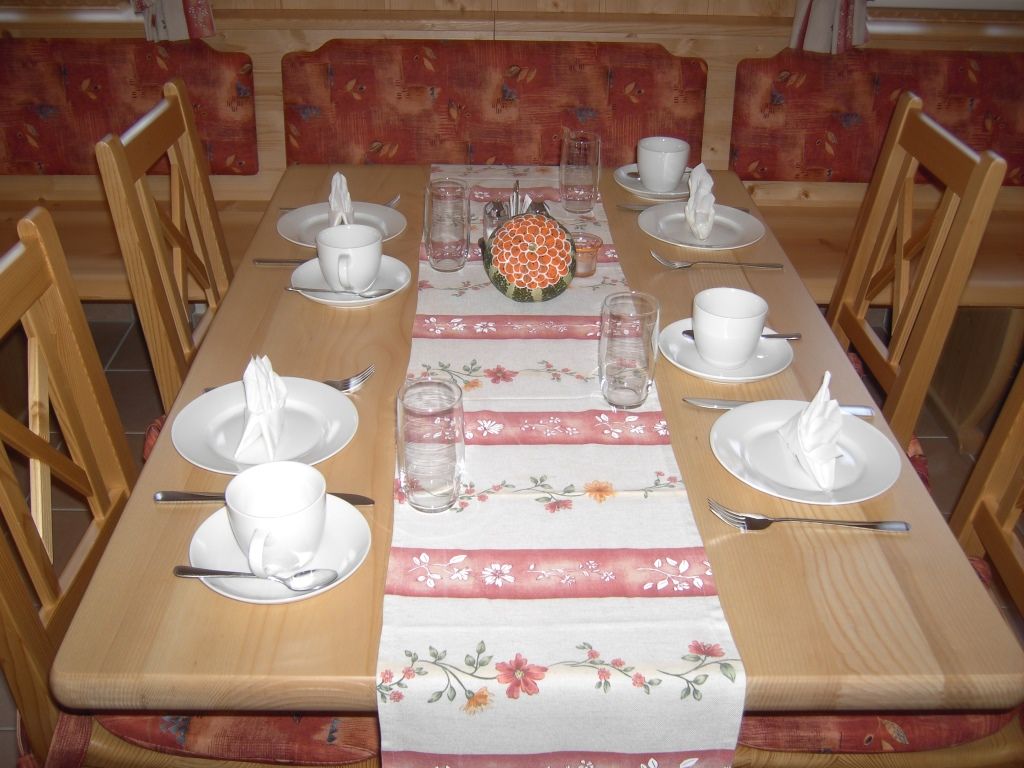 Položený stôl v raňajkovej miestnosti s riadom a pohármi.