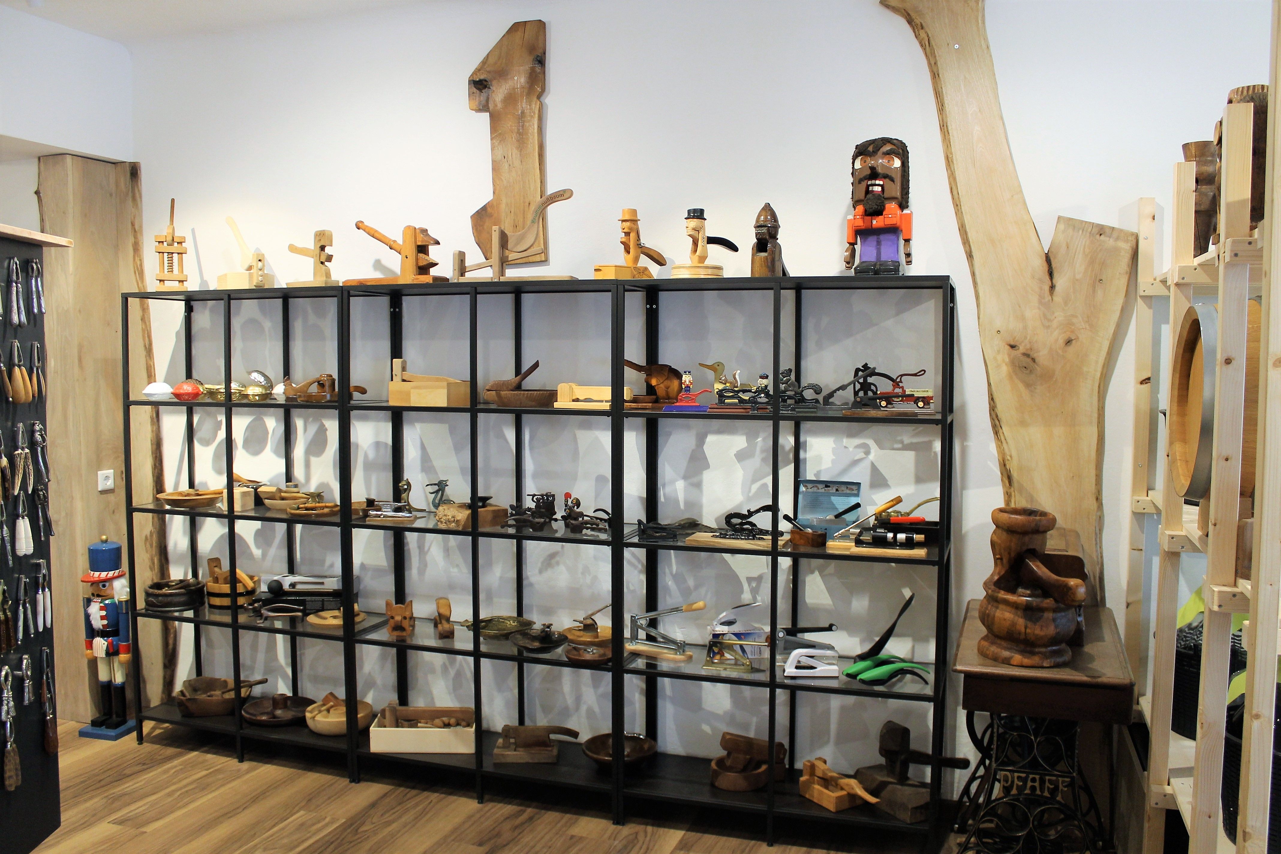 Regál s drevenými predmetmi a náradím v predajni.