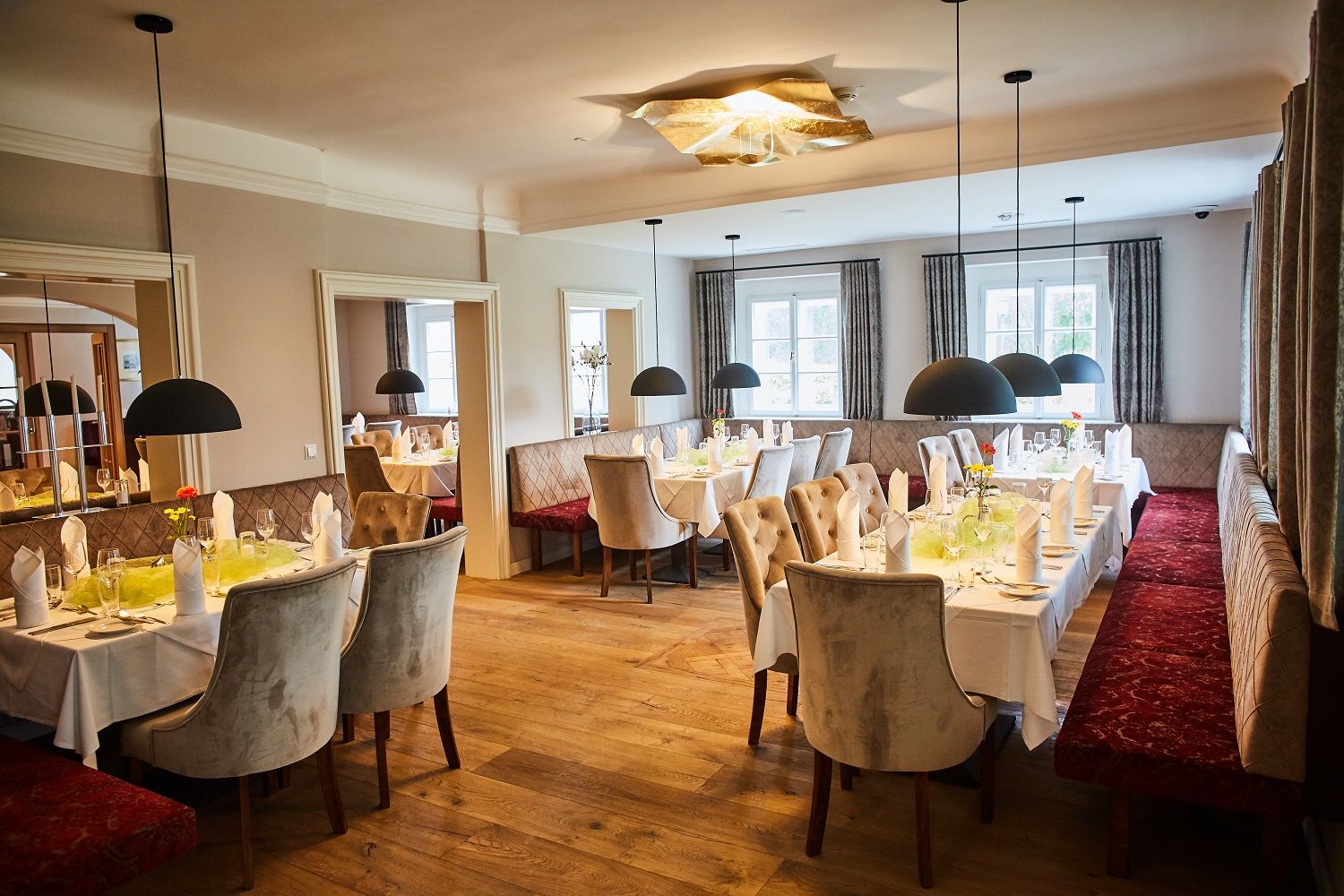 Elegantná reštaurácia s prestretými stolmi a štýlovým osvetlením.