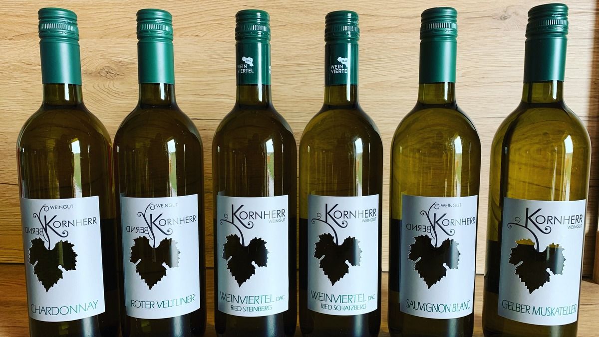 Šesť fliaš vína z vinárstva Kornherr na drevenom stole.