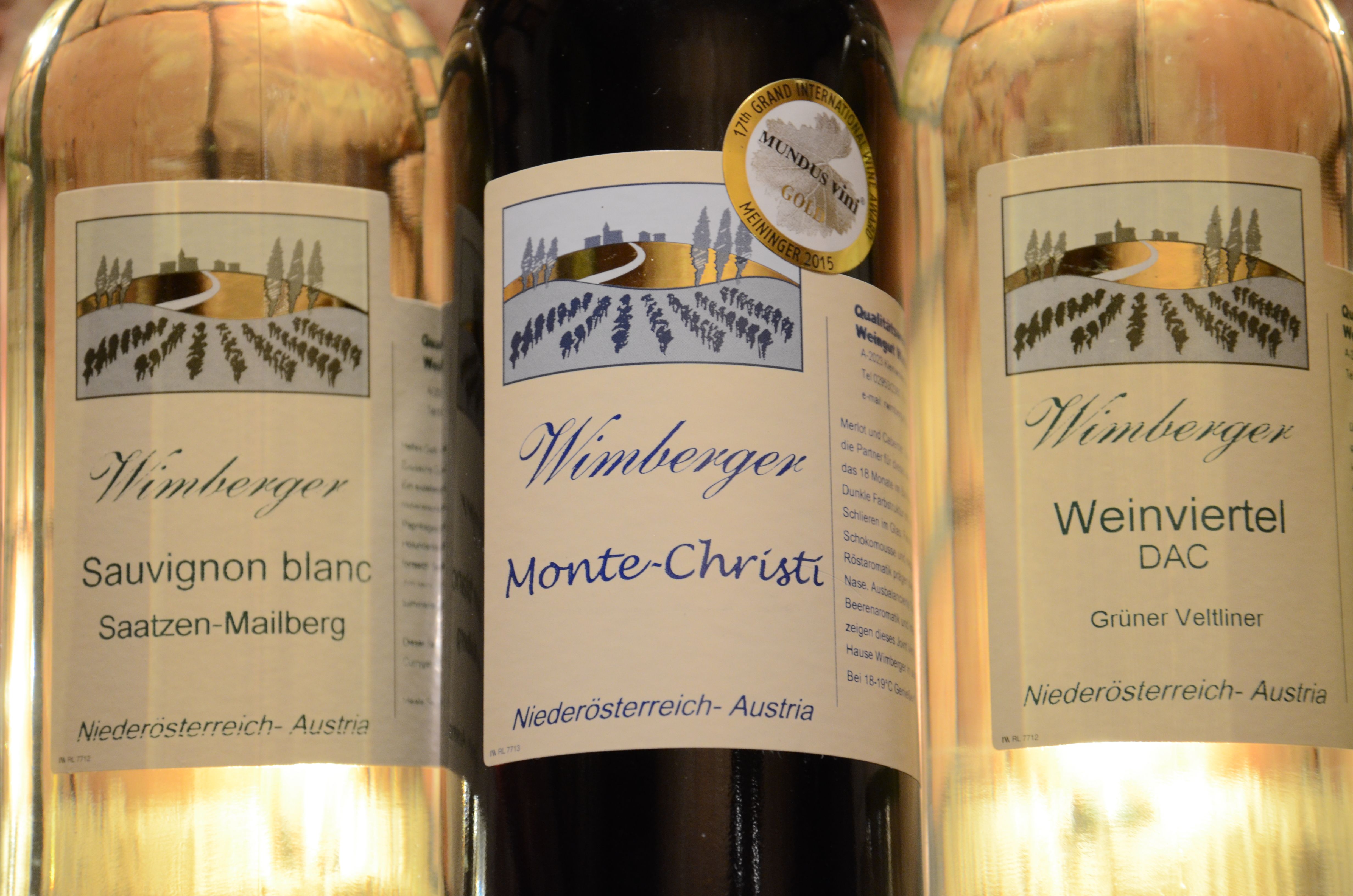 Tri fľaše vína značky Wimberger s etiketami pre Sauvignon Blanc, Monte-Christi a Weinviertel DAC.
