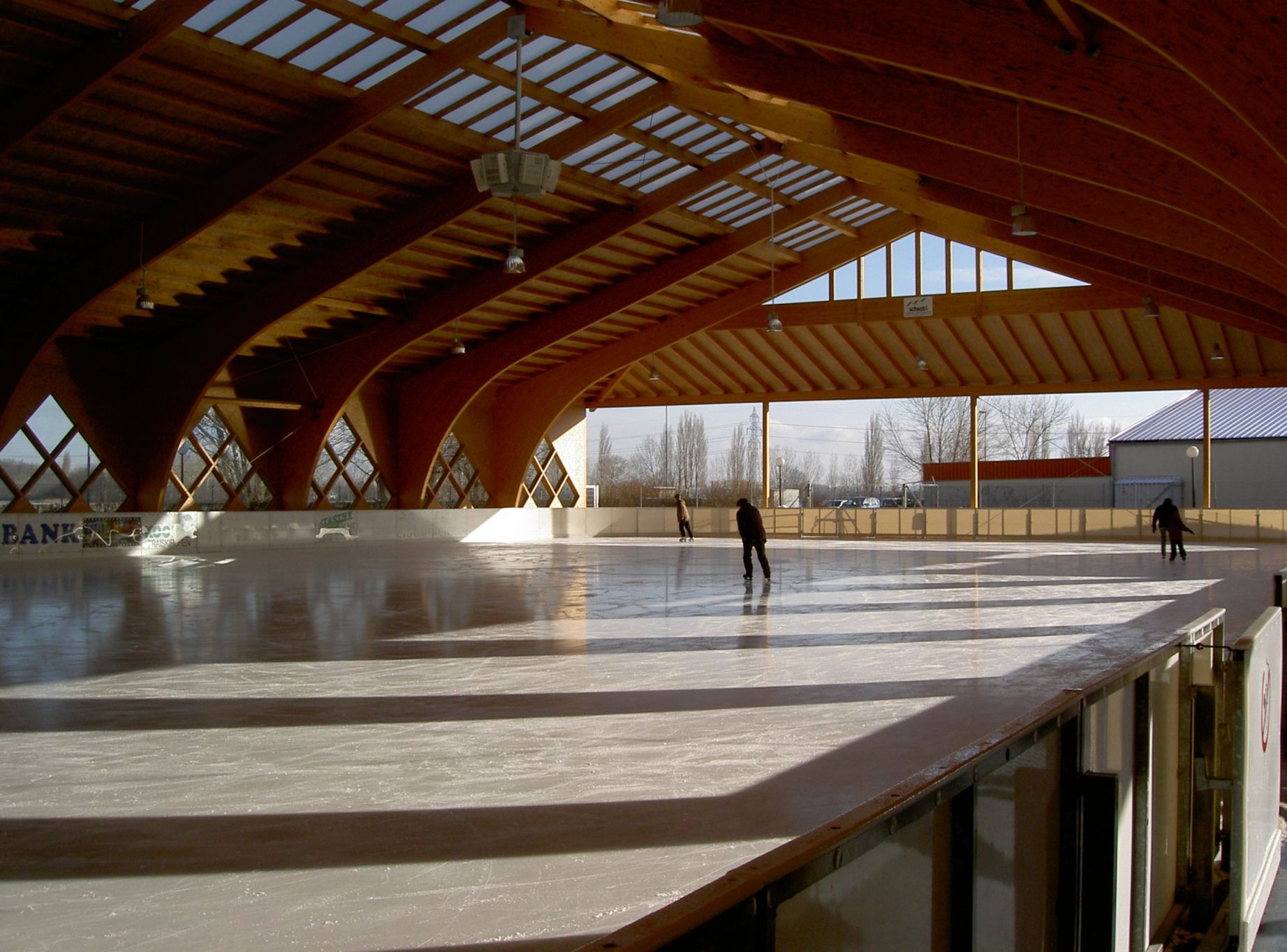 Kryté umelé klzisko s drevenou konštrukciou a korčuliarmi.