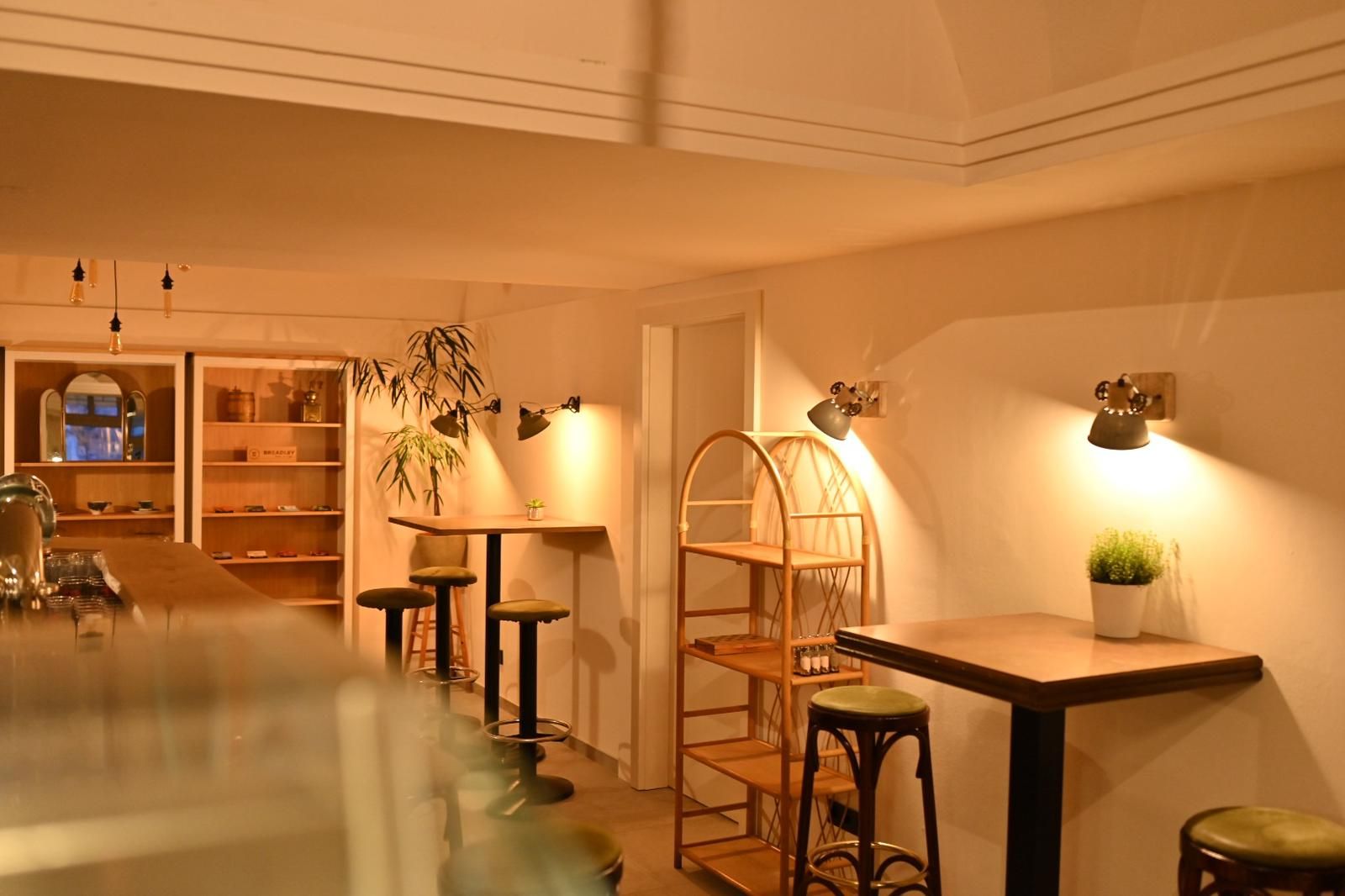 Pohľad do interiéru útulnej kaviarne s dreveným nábytkom a teplým svetlom.