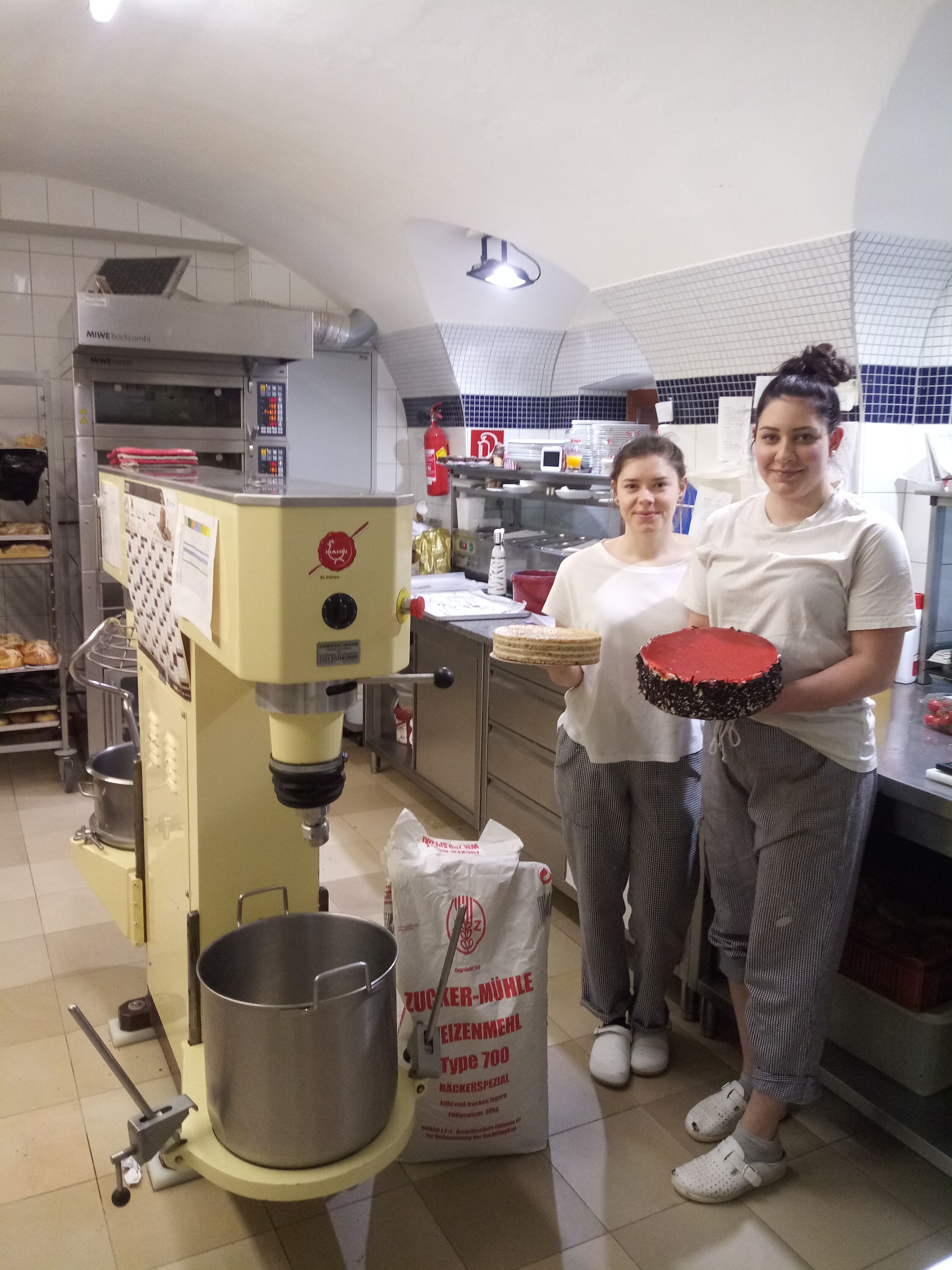 Dvaja ľudia v pekárni s tortou a tortovým základom.