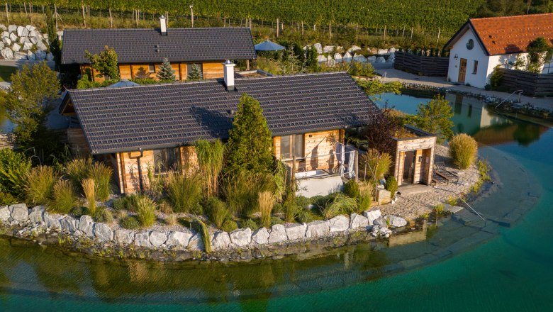 Leteck&yacute; pohľad na chaty na z&aacute;hradnom jazere s m&oacute;lom a ležadlom.