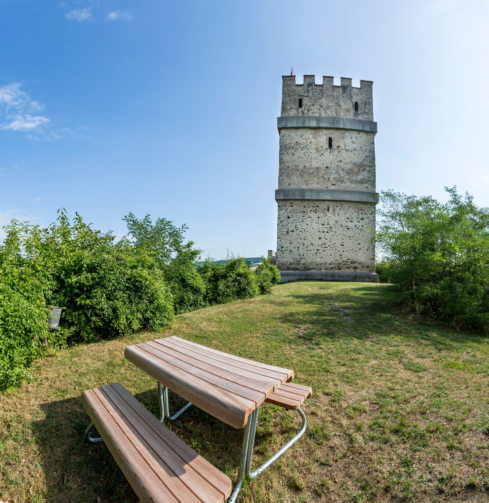Požiarna veža zrúcaniny hradu Kirchschlag s piknikovým stolom v popredí.