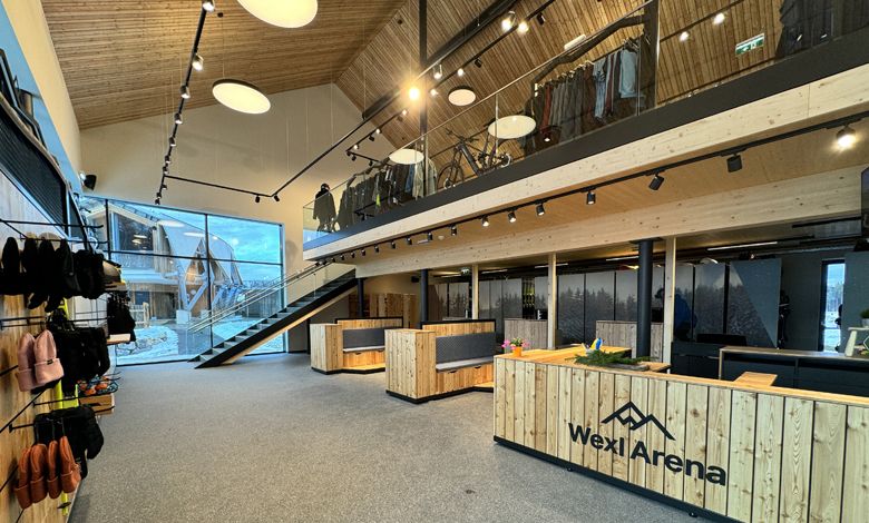 Pohľad do interiéru servisného centra Wexl Base s dreveným nábytkom a schodiskom.