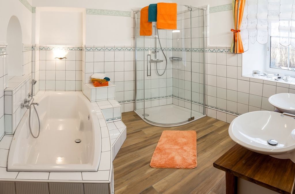 Moderná kúpeľňa s vaňou, sprchovacím kútom a dvojitým umývadlom.
