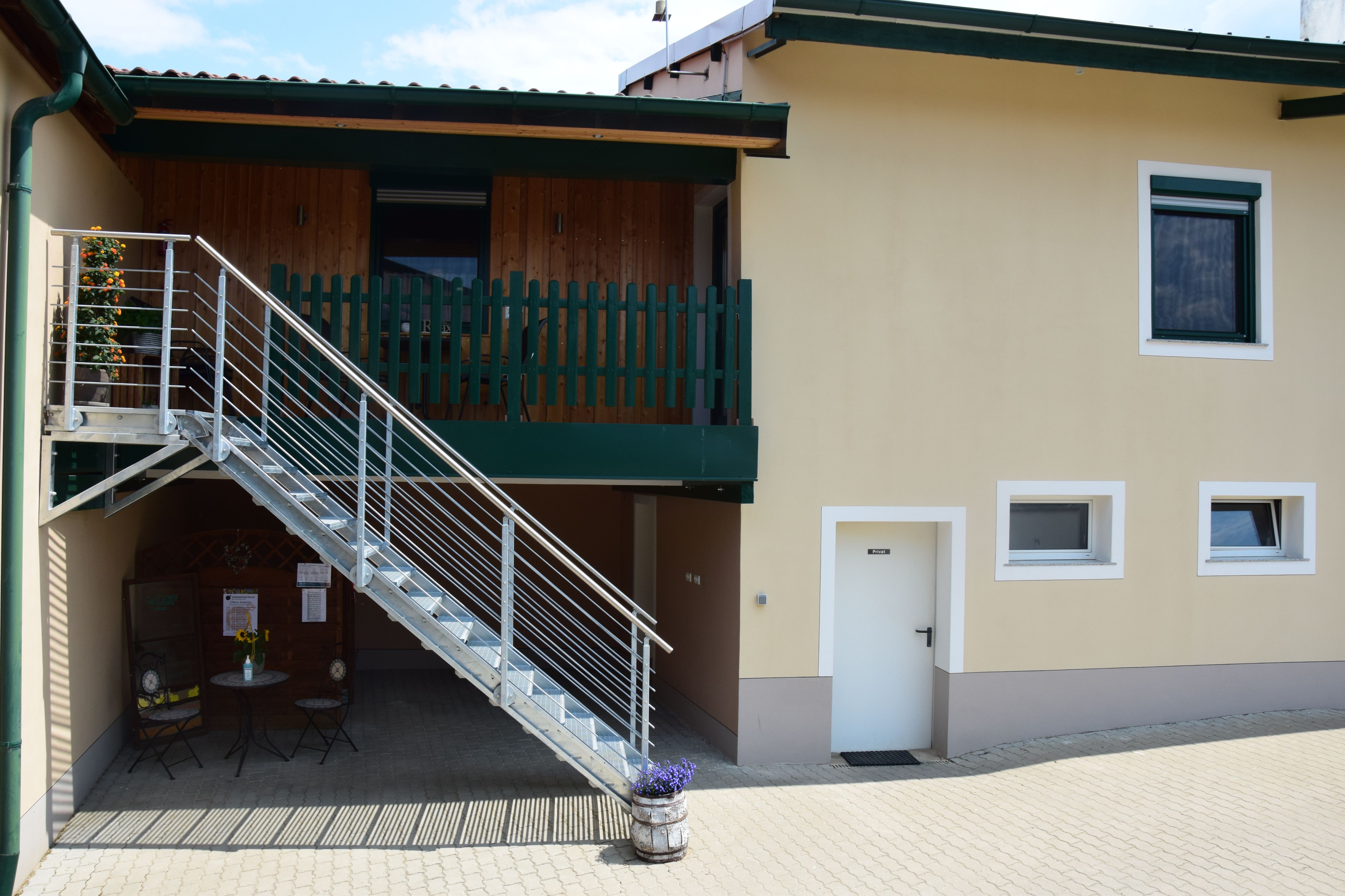 Exteriérový pohľad na budovu so schodiskom a balkónom.