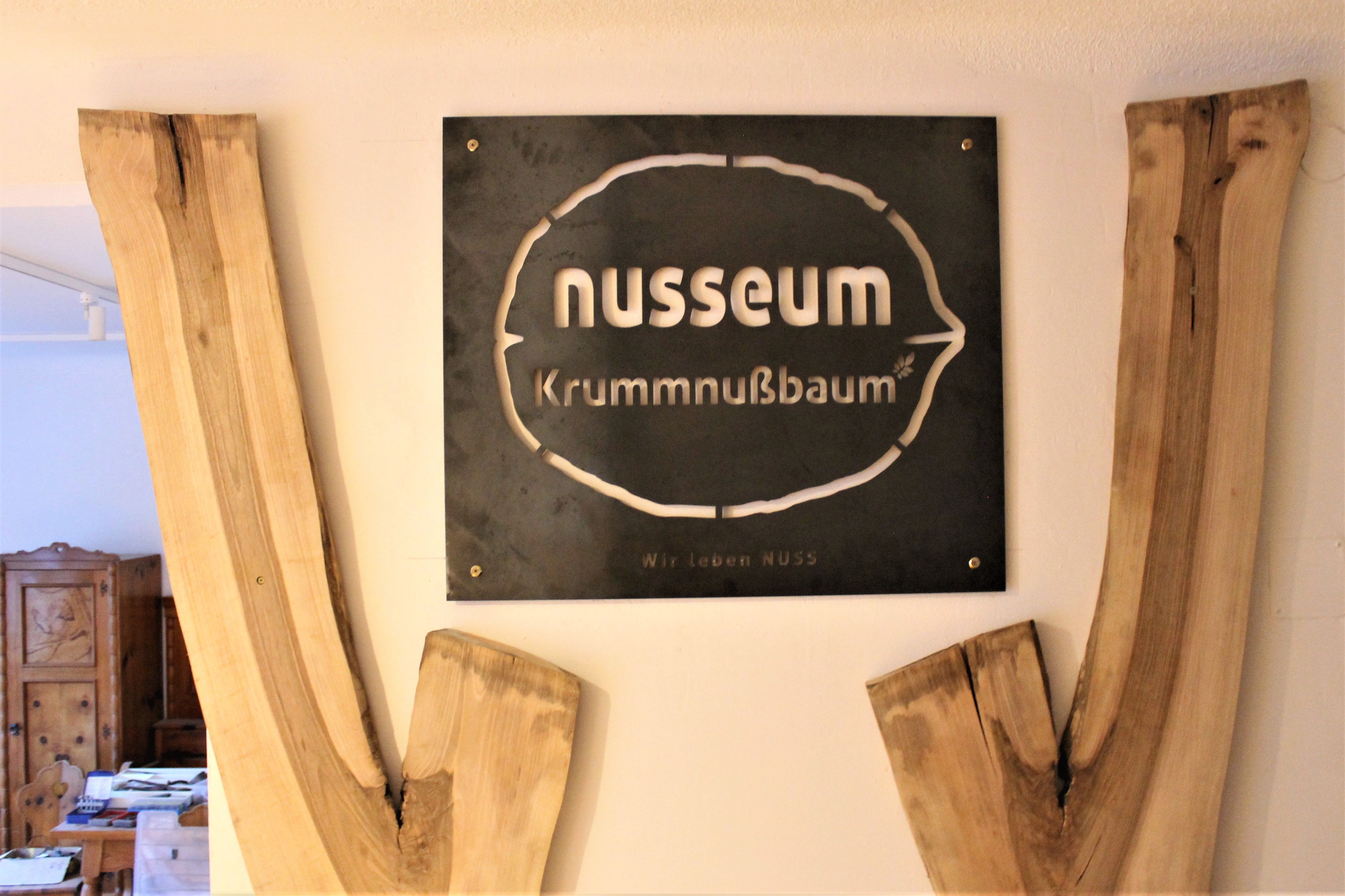 Nápis Nusseum Krummnußbaum s drevenou výzdobou.