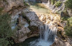 Kristallklares Wasser plätschert sanft über die Felsen und schafft eine harmonische Melodie der Natur. Umgeben von üppigem Grün und majestätischen Felsen lädt diese idyllische Landschaft zum Verweilen und Entdecken ein. Hier, wo die Ruhe der Berge auf die Frische des Wassers trifft, wird jeder Schritt zu einem unvergesslichen Erlebnis.