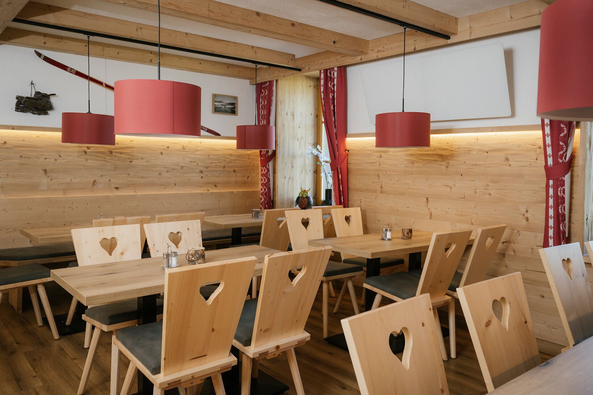 Jedáleň s drevenými stolmi a stoličkami s motívom srdca v Damböckhaus na Schneebergu