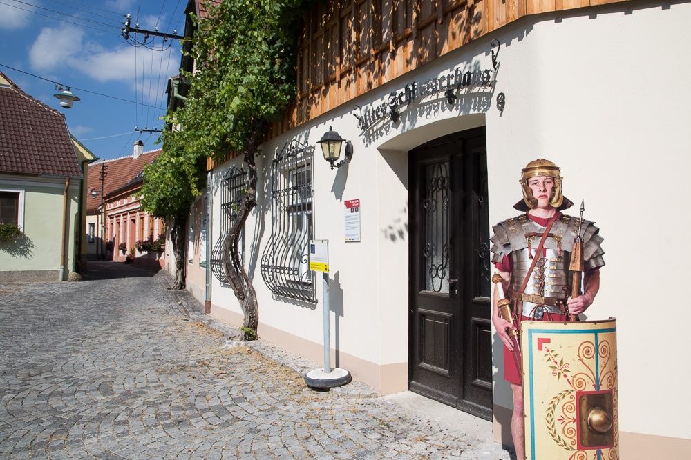 Kartónová expozícia rímskeho vojaka stojí pred budovou v Traismauer.