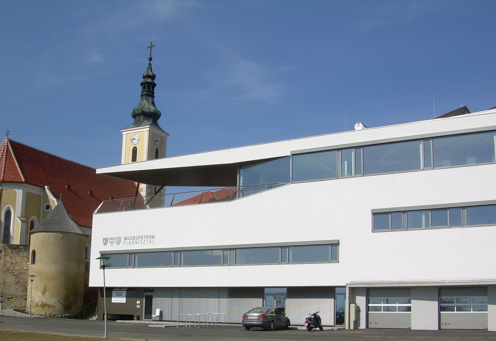 Moderná budova s kostolnou vežou v pozadí vo Wölblingu.