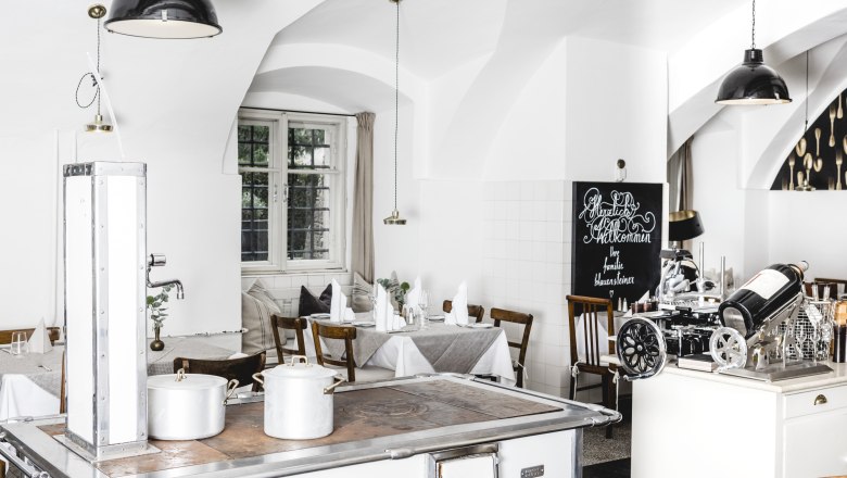 Svetl&yacute; interi&eacute;r re&scaron;taur&aacute;cie s bielymi stenami, dreven&yacute;m n&aacute;bytkom a star&yacute;m spor&aacute;kom.