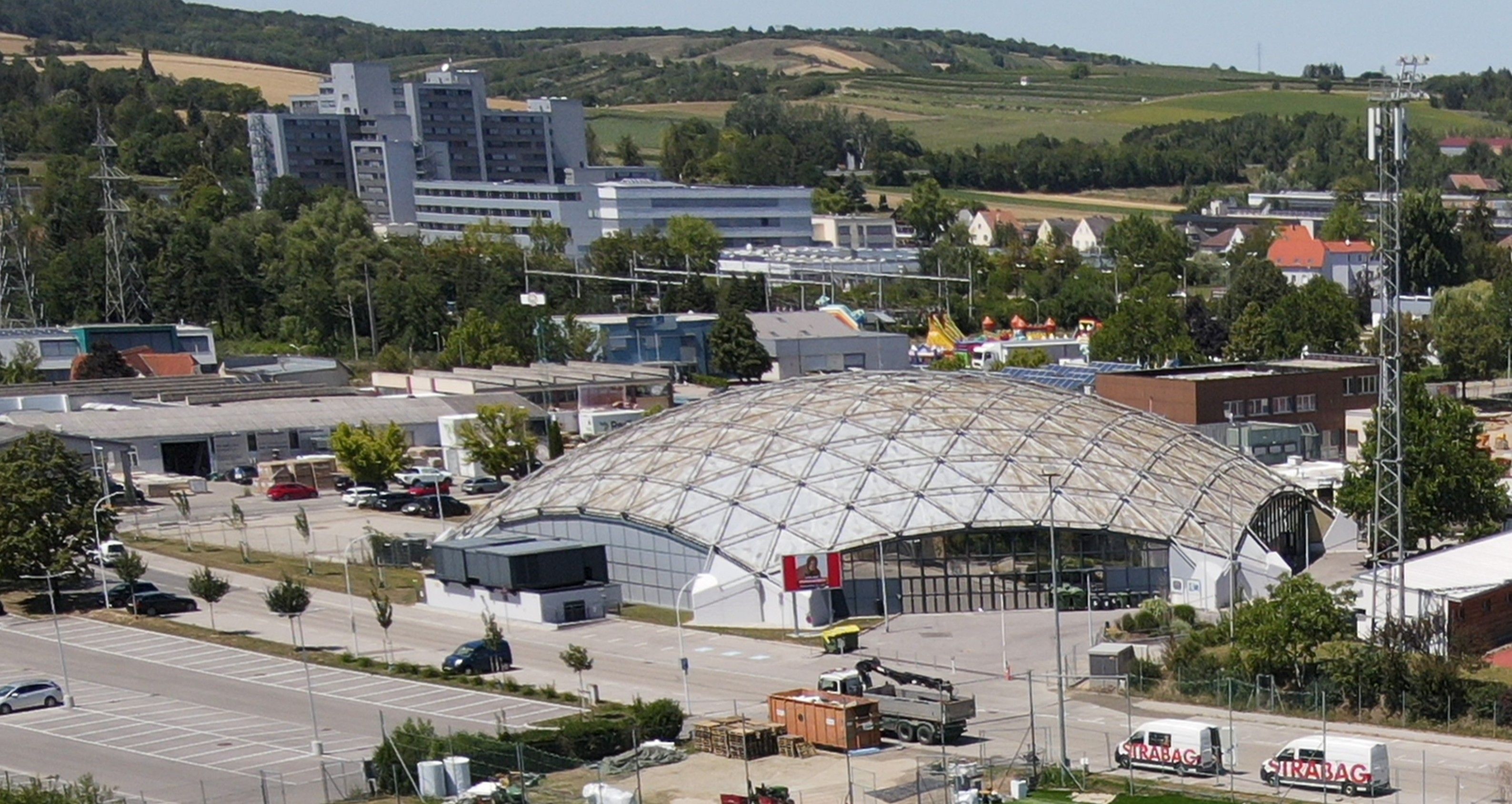 Letecký pohľad na športovú halu v Hollabrunne s okolitými budovami a krajinou.