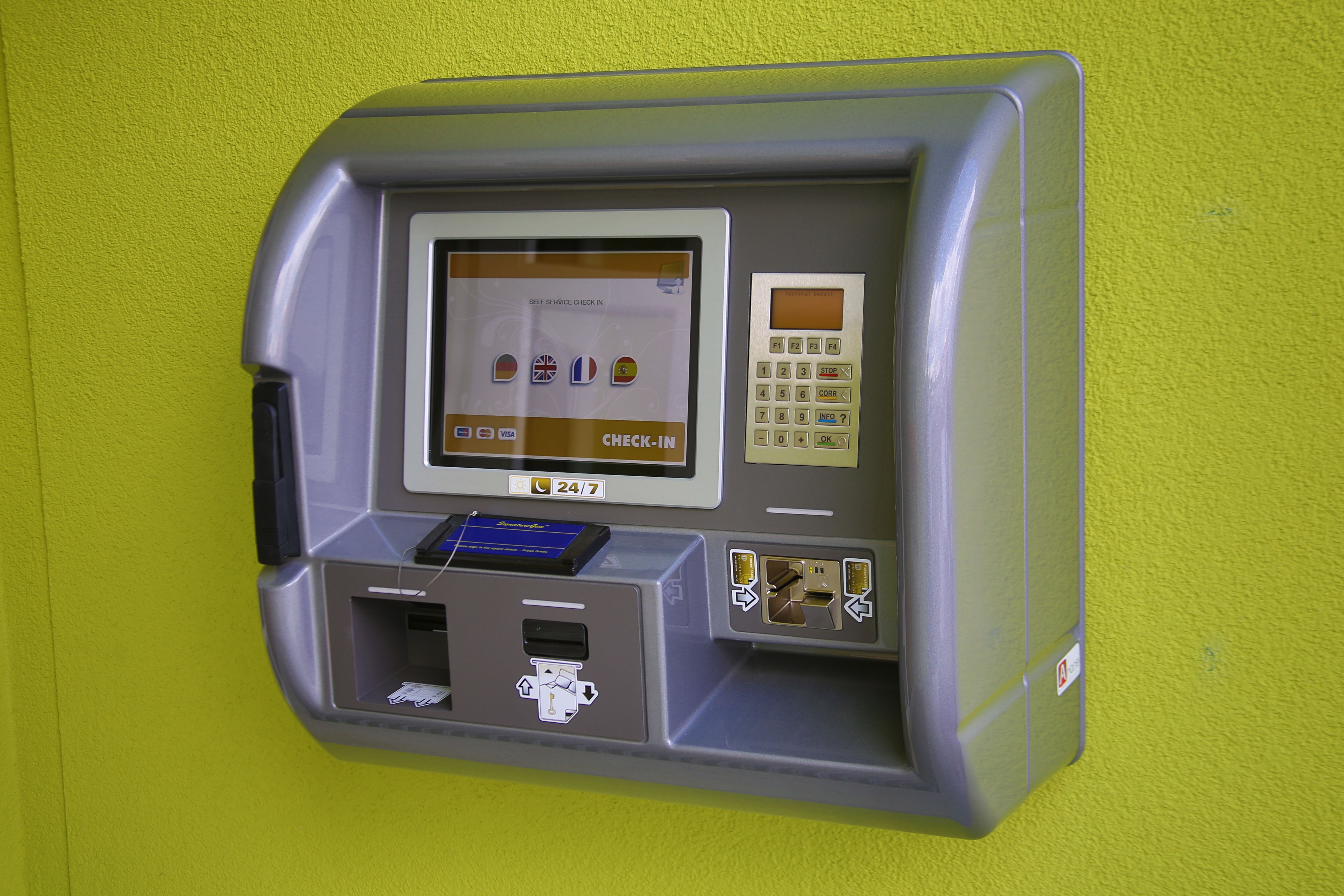 Odbavovací automat na zelenej stene.