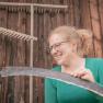 Julia grinding the scythe, © Einkehrhof Poggau