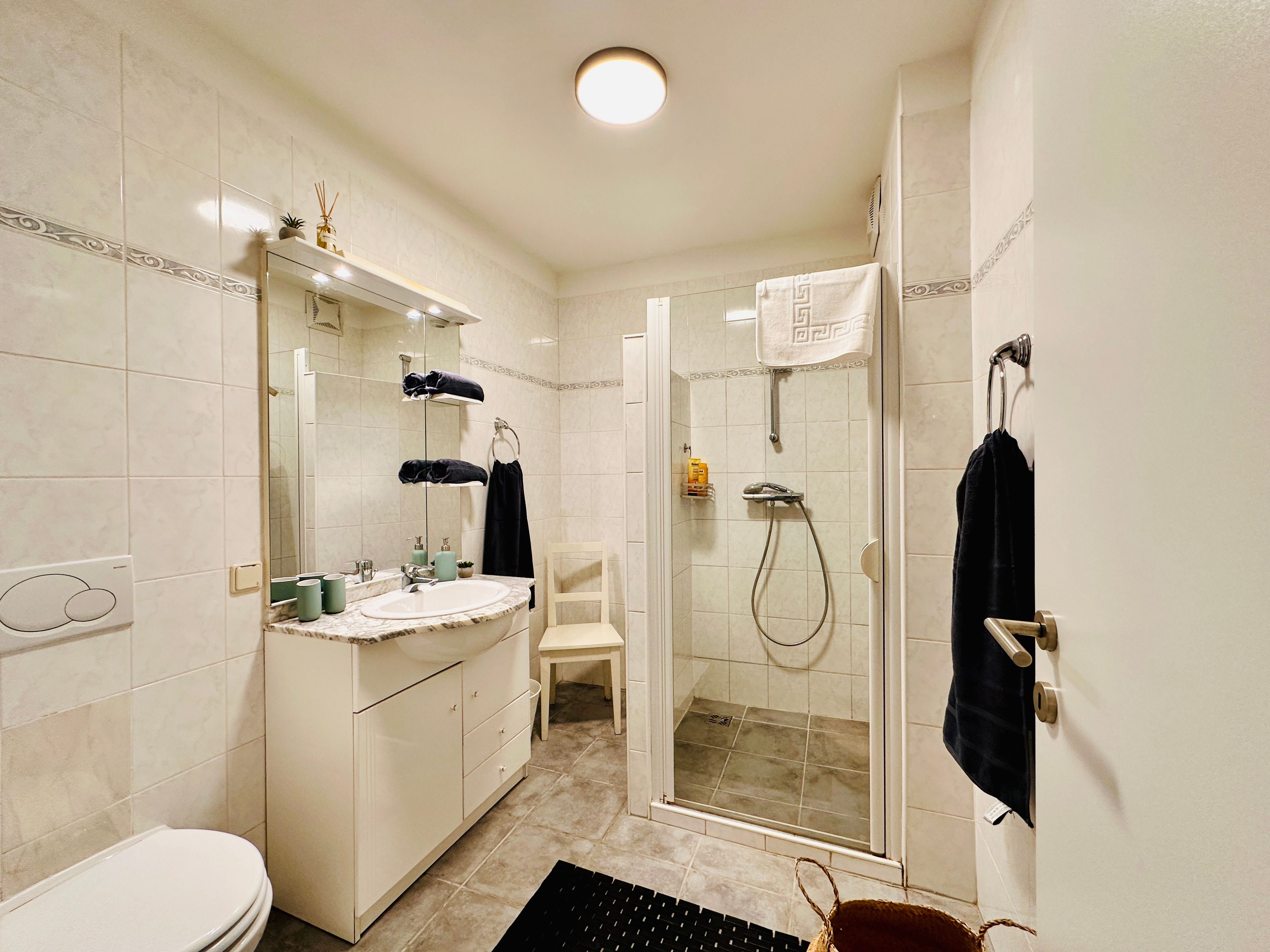 Moderná kúpeľňa so sprchovacím kútom, umývadlom a WC.