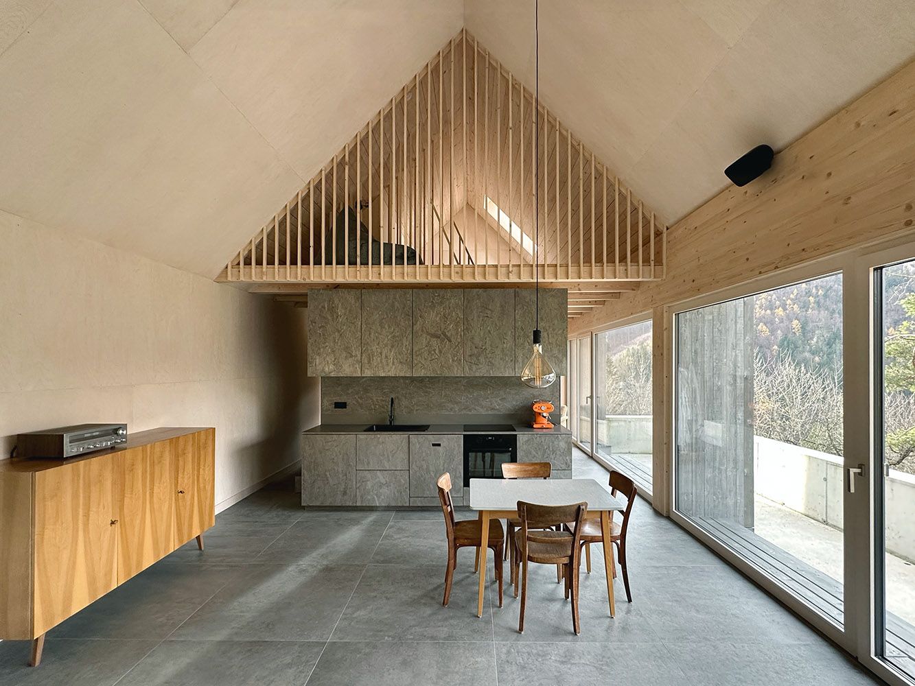 Moderná otvorená kuchyňa s drevenými prvkami a veľkými oknami.