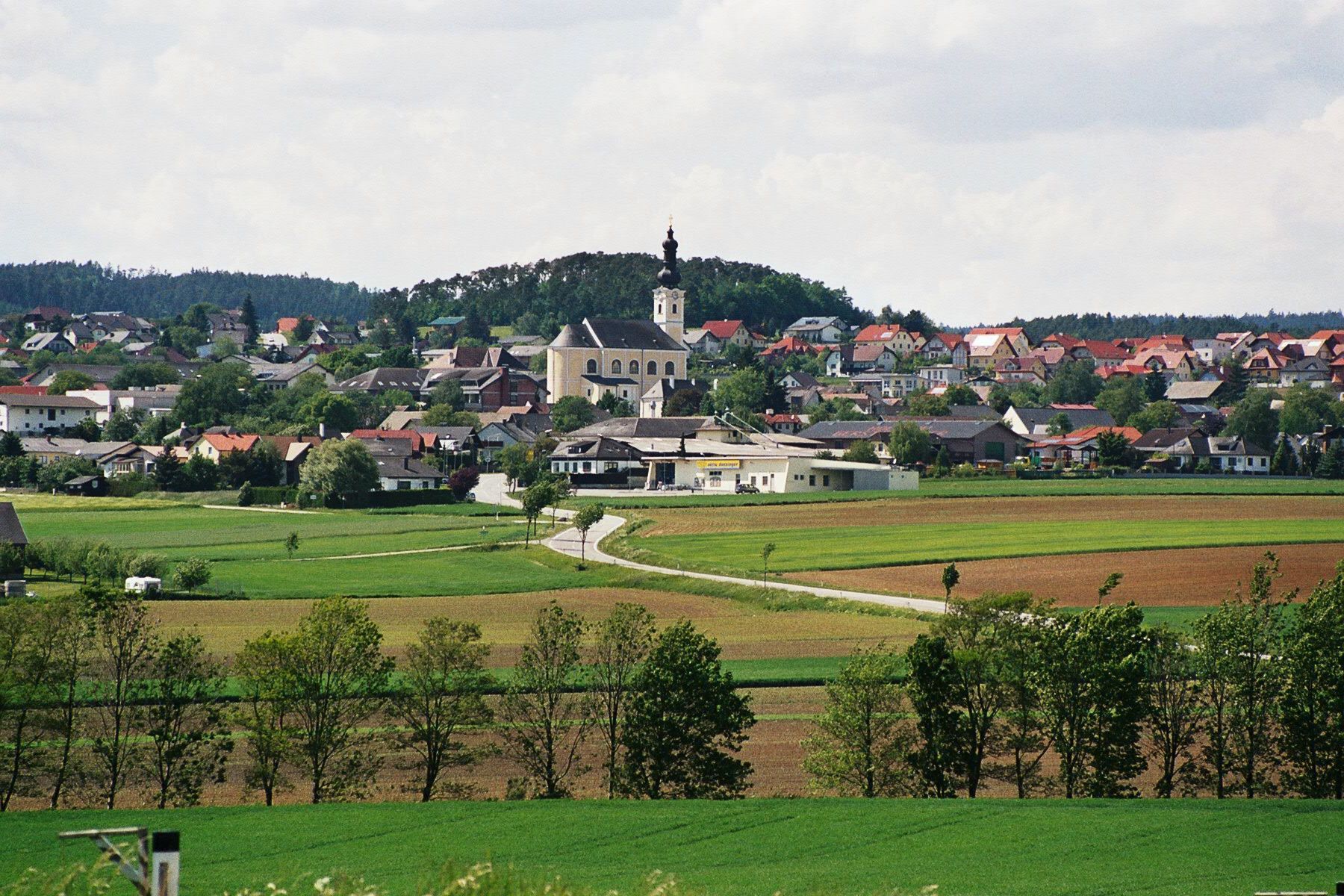 Panoráma trhového mestečka Karlstetten s kostolom a okolitými poliami.
