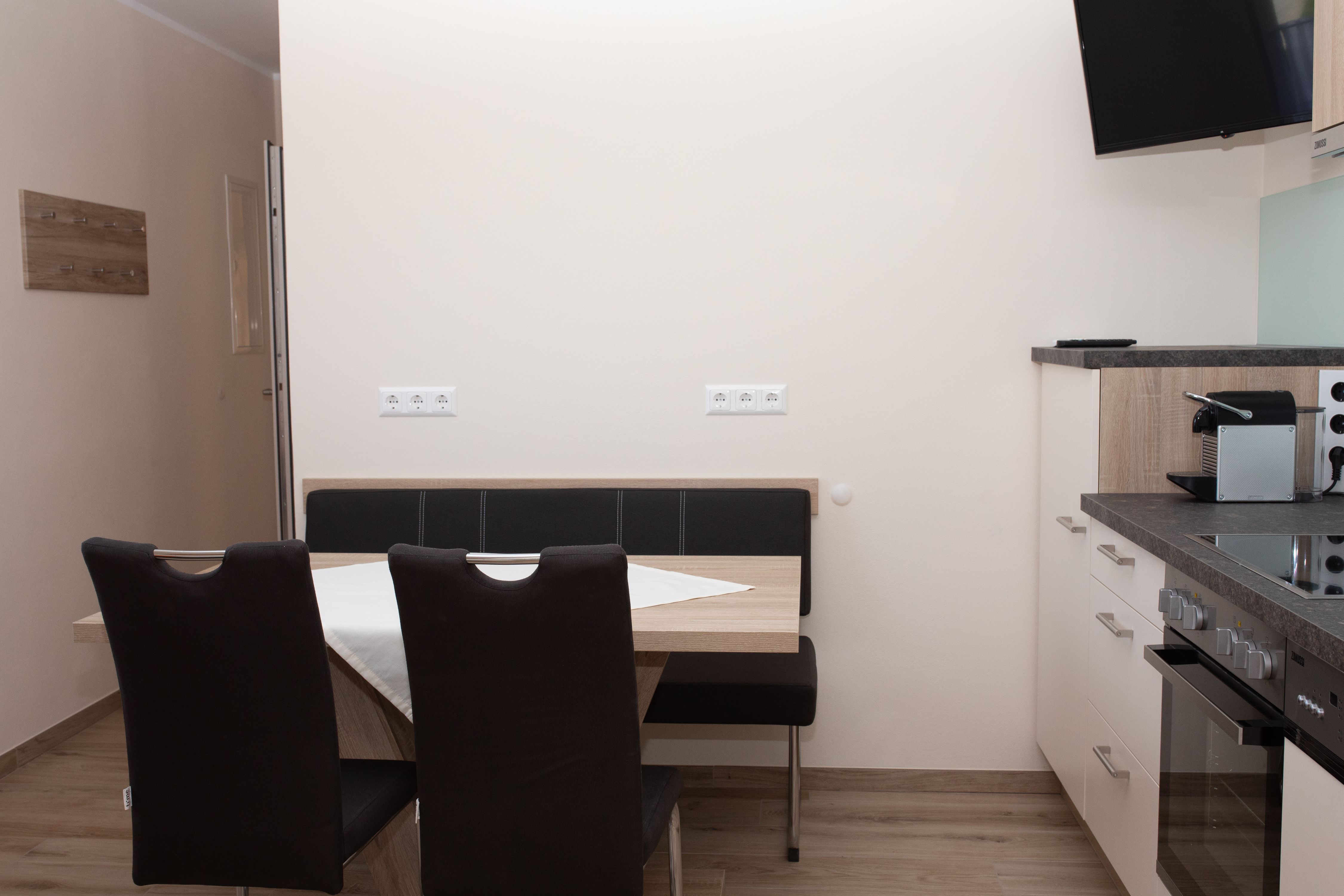 Jedálenský kút so stolom, stoličkami a kuchynským kútom.