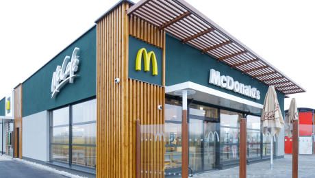 Exteriérový pohľad na modernú reštauráciu McDonald's s logom McCafé.