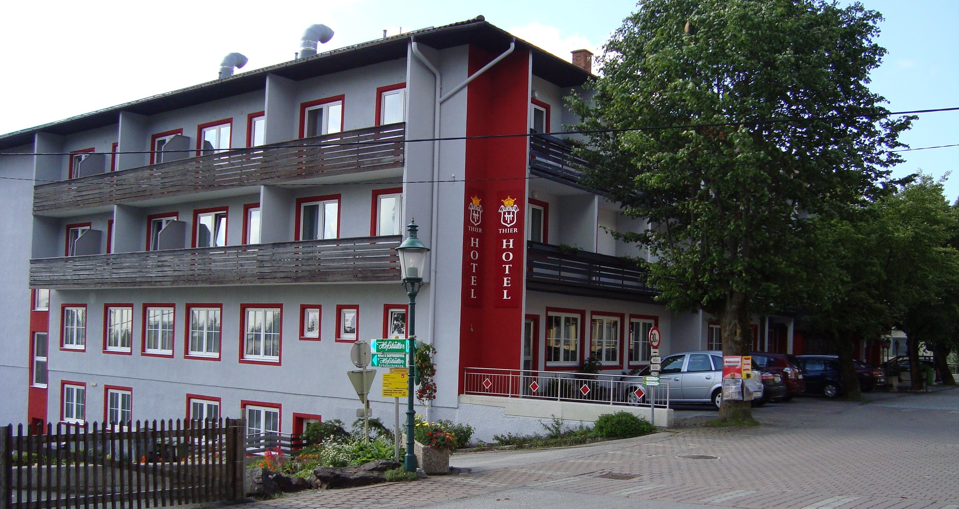 Exteriérový pohľad na hotel Thier s balkónmi a červeným nápisom.