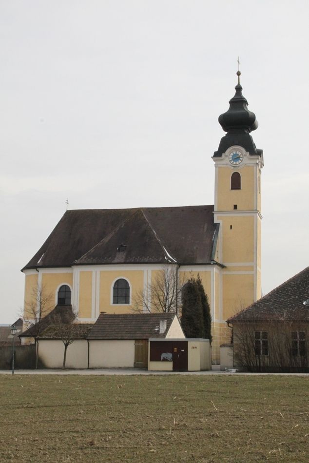 Farský kostol Langenrohr so žltou fasádou a cibuľovou kupolou.