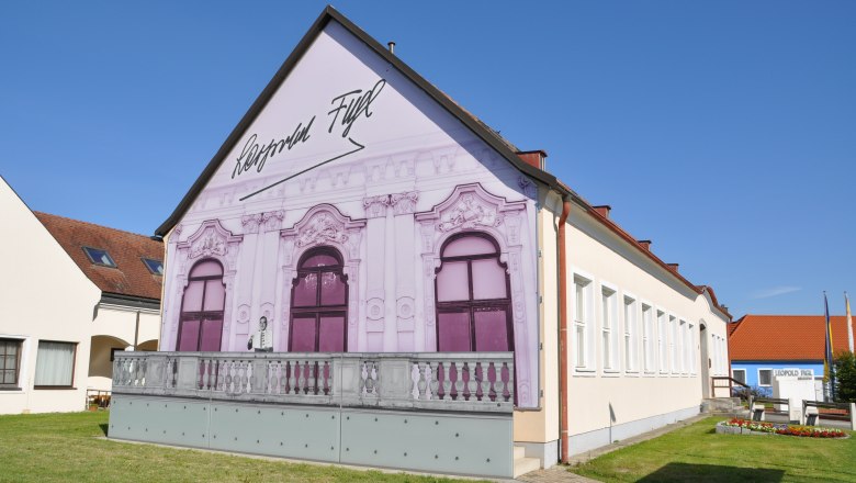 Leopold Figl Museum mit bemalter Fassade und blauen Himmel.