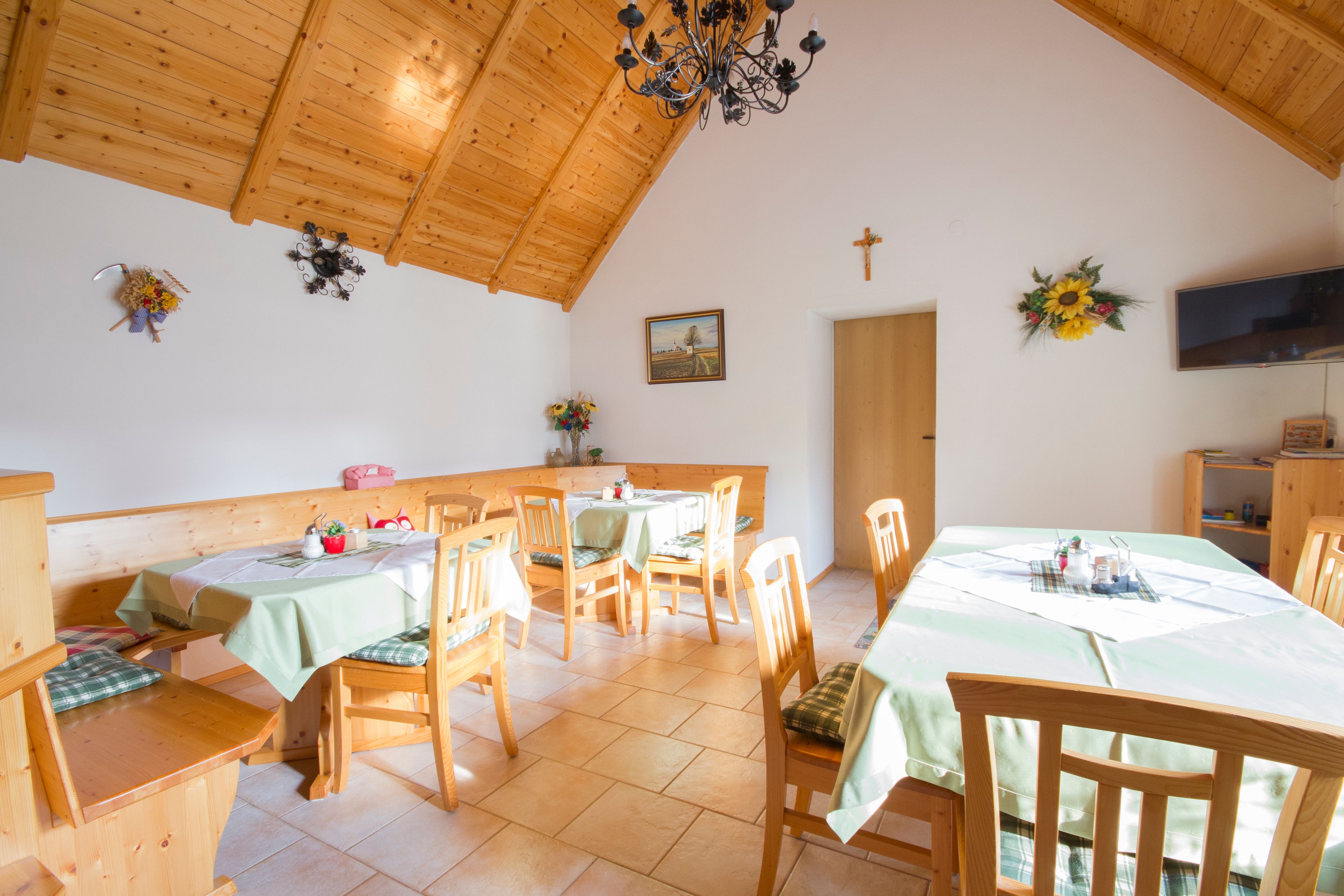 Útulná izba s dreveným nábytkom a zdobenými stolmi.