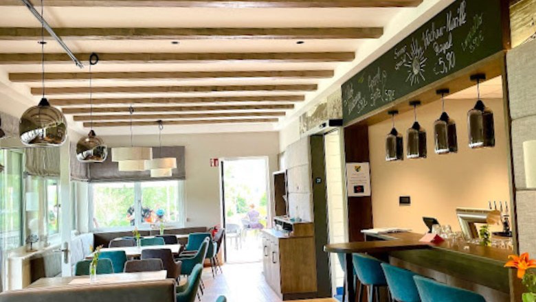 Re&scaron;tauračn&aacute; časť vo vn&uacute;tri so stolmi a zelen&yacute;mi kreslami