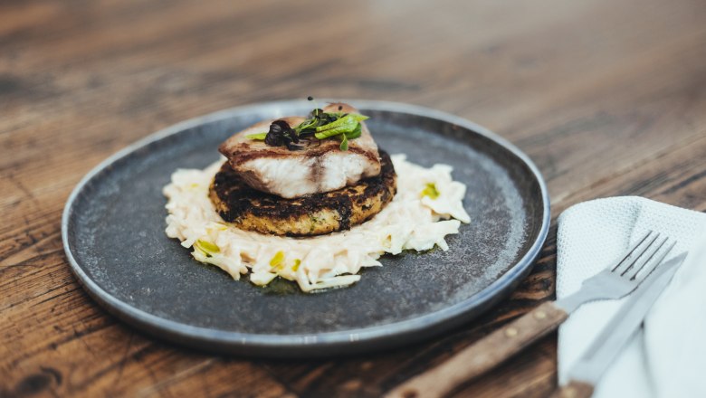 Jedlo s rybou na rösti a kapustou na tanieri.