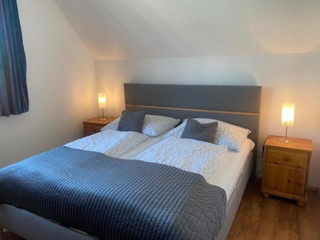 Útulná spálňa s manželskou posteľou, dvoma nočnými stolíkmi a lampami.