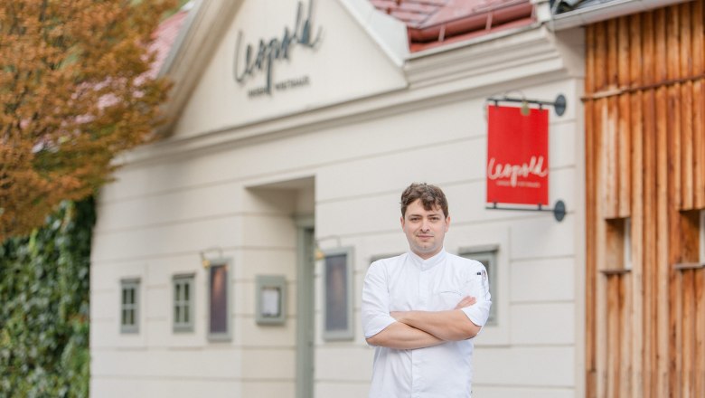 Kuchár v bielej uniforme pred reštauráciou Leopold.