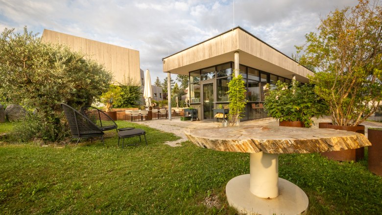 Záhrada moderného hotela s posedením a rastlinami.